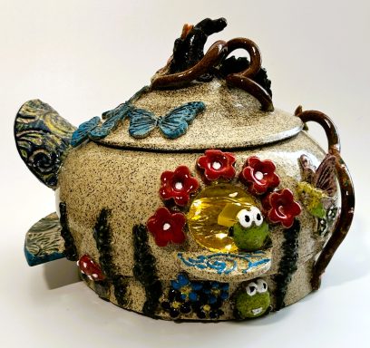 Speckled clay base lidded vessel. Hand painted fairy garden themed appliques. Yellow glazed interior. Lights. H-6.5in x Diameter-7in.